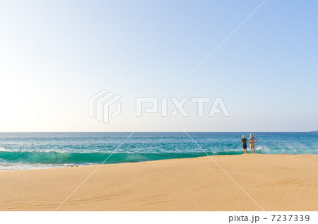 ハワイ　モロカイ島　パポハクビーチ　波を眺める2人 7237339