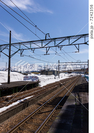 小出駅の線路と雪山　新潟県魚沼市 7242356