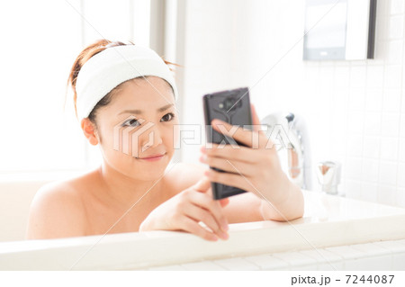 風呂でスマホを見る女性 7244087