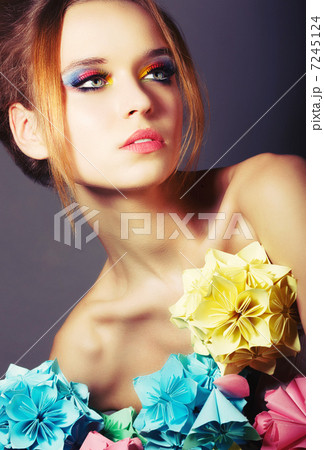 Portrait of Young Beauty with Colorful Origami Flowers. Bright Eye Make-Up 7245124
