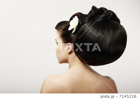 Haircare. Fashion Model with Creative Hairstyle. Smooth Healthy Black Hair with Flower. Spa Salon 7245226