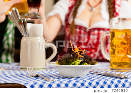 People in traditional Bavarian Tracht eating in restaurant or pub 7245930