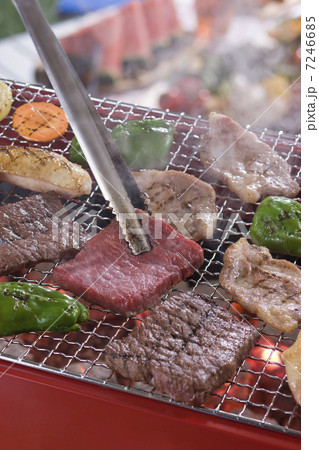 バーベキューコンロで肉を網焼きにする 7246685