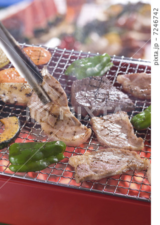 バーベキューコンロで肉を網焼きにする 7246742