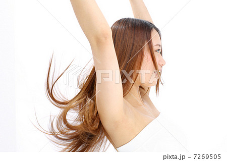 髪をかきあげる女性の写真素材