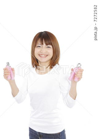 ハンドグリッパーを握り締める若い女性 7272582