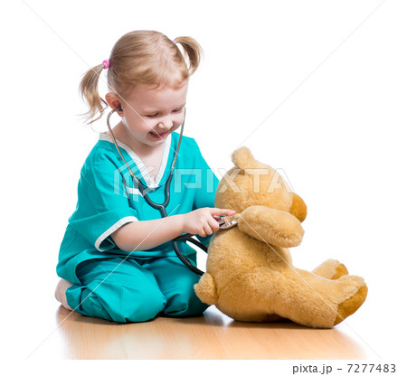 Adorable child with clothes of doctor playing with plush toy 7277483
