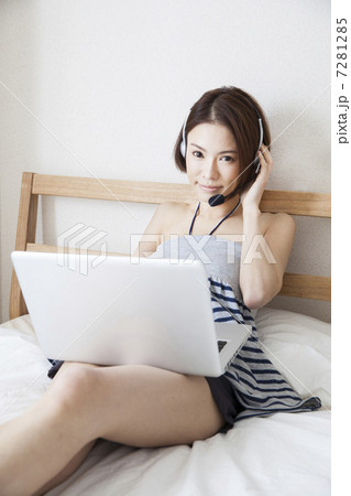 ヘッドセットを付けてPCを見ている女性 7281285