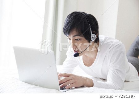 ヘッドセットを付けてPCを見ている男性 ヘッドセットを付けてPCを見ている男性 7281297