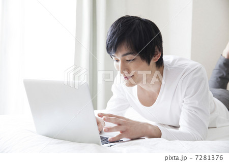ベッドルームでPCを見ている男性 7281376