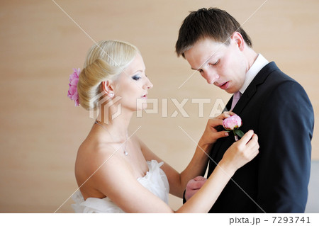 Bride adjusting grooms boutonniere 7293741