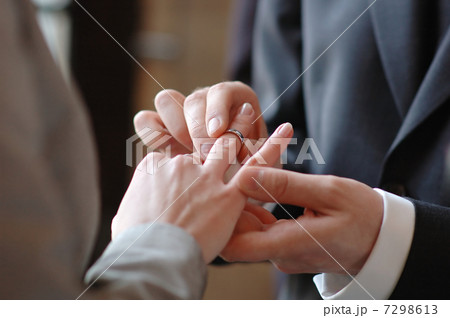 Groom putting a ring on brides finger Groom putting a ring on brides finger 7298613