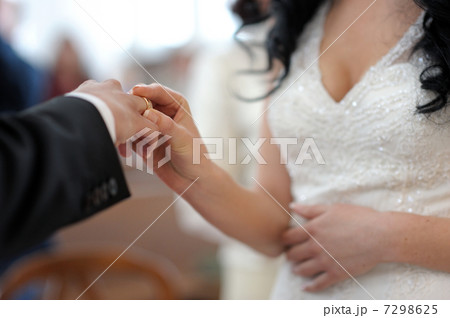 Bride putting the ring on grooms finger 7298625