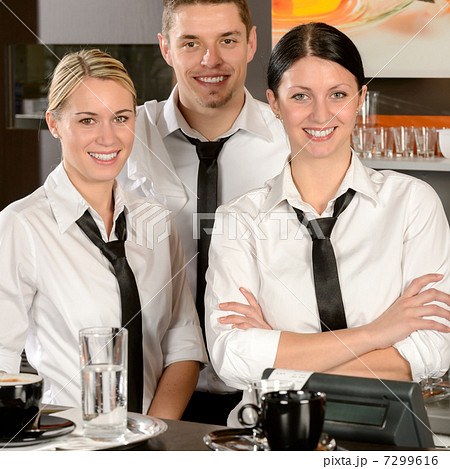 Three server posing in uniform in cafe 7299616