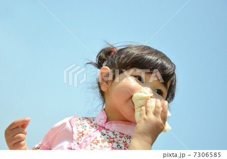 公園で肉まんを食べる女の子 7306585