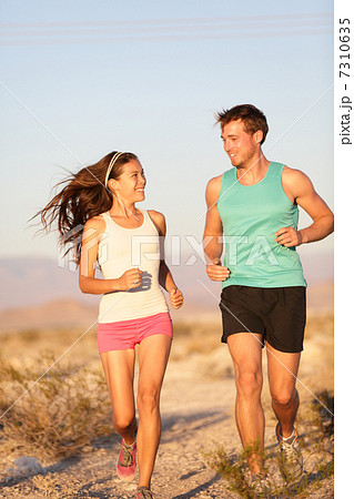 Runners - Active fitness couple running laughing 7310635