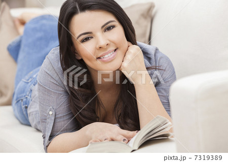 Happy Hispanic Woman Reading Paperback Book at Home Happy Hispanic Woman Reading Paperback Book at Home 7319389