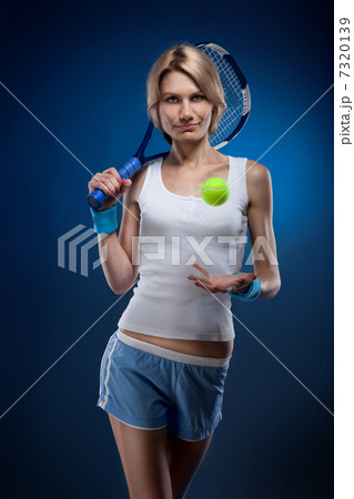 smiling woman with a tennis ball and racquet on blue smiling woman with a tennis ball and racquet on blue 7320139