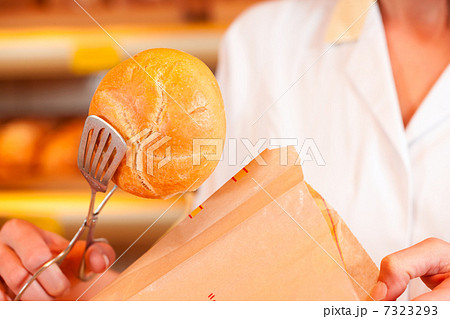Salesperson is packing bread in bakery Salesperson is packing bread in bakery 7323293