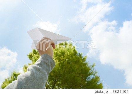 紙ひこうきを飛ばす女性 7325404