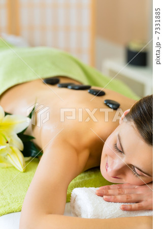 woman having wellness hot stone massage woman having wellness hot stone massage 7331885