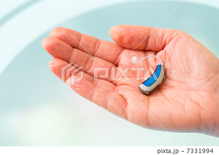 Hand holding hearing aid 7331994