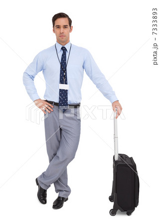 Handsome young businessman waiting with his suitcase Handsome young businessman waiting with his suitcase 7333893