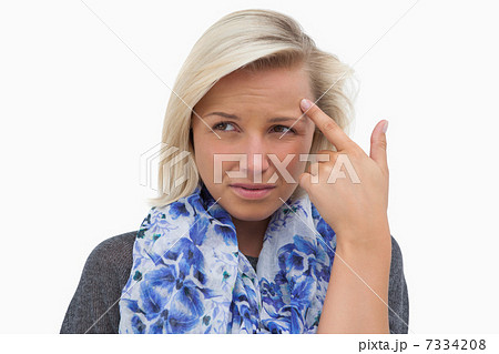 Anxious blonde pointing to forehead 7334208