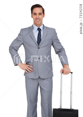 Smiling young businessman waiting with his luggage 7334258