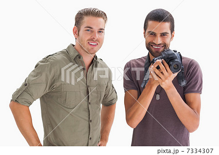Stylish friends smiling with one holding camera Stylish friends smiling with one holding camera 7334307