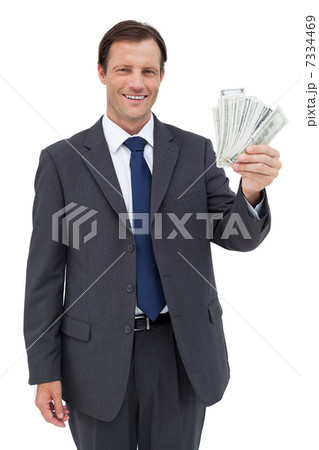 Smiling businessman holding dollar bills 7334469