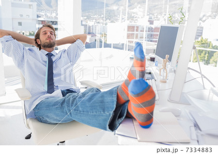 Designer relaxing at desk with no shoes Designer relaxing at desk with no shoes 7334883