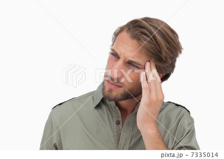 Man with headache looking away and touching his head 7335014