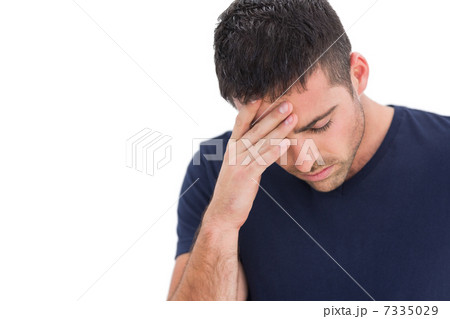 Upset man standing with his hand holding his forehead 7335029
