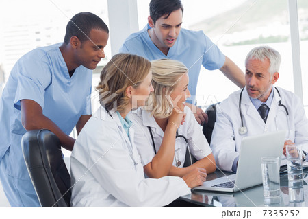 Smiling medical team using laptop Smiling medical team using laptop 7335252