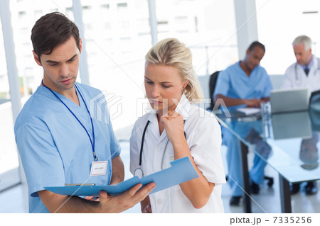 Two doctors examining a file Two doctors examining a file 7335256