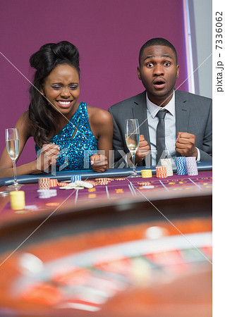 Couple sitting at roulette table waiting anxiously for wheel to 7336062