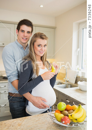 Pregnant woman holding banana with partner Pregnant woman holding banana with partner 7336248