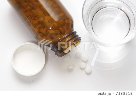 錠剤の入った薬ビンとコップの水 7338218