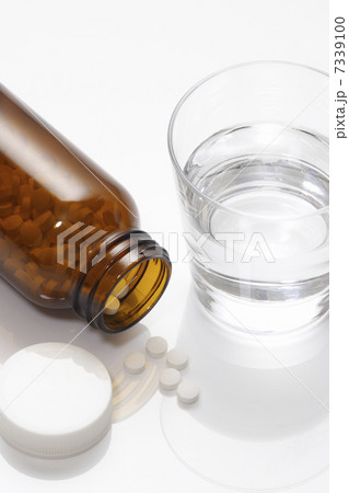 錠剤の入った薬ビンとコップの水 7339100
