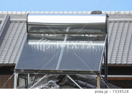 民家の屋根の太陽光給湯設備と青空 7339528