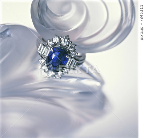 香水の瓶の上に置かれたサファイヤの指輪 7345311