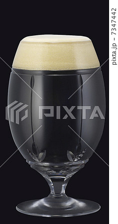 グラスに注がれて綺麗な泡を載せた黒ビール 7347442