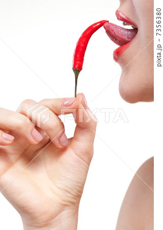 Young woman with chili pepper isolated on white Young woman with chili pepper isolated on white 7356380