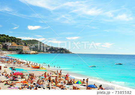 tourists, sunbeds and umbrellas on summer hot day 7385582