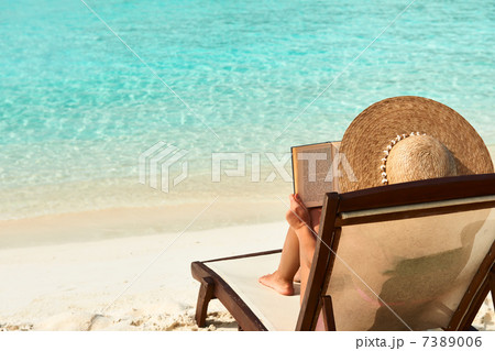 Young woman reading a book at beach 7389006