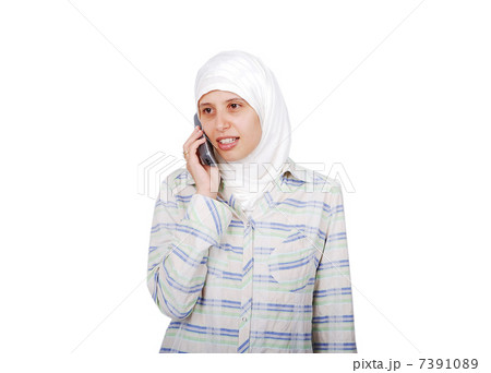 A young muslim woman in traditional clothes isolated speaking on phone A young muslim woman in traditional clothes isolated speaking on phone 7391089