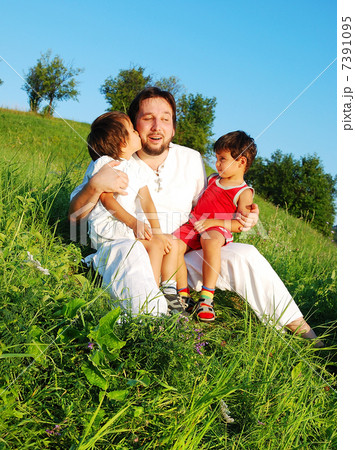 Young father in white with children on beautiful meadow 7391095