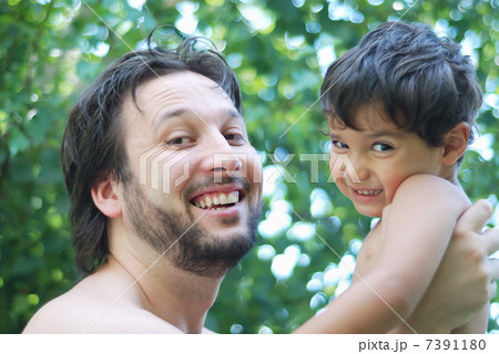 Lovely boy and his father holding him in hands in nature Lovely boy and his father holding him in hands in nature 7391180