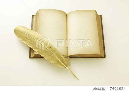 金の羽とアンティークの本の写真素材